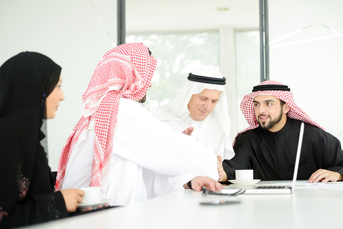 A photo of men discussing UAE virtual phone systems.